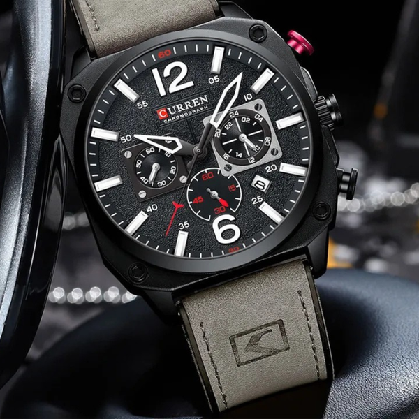 Curren watch with black dial and gray leather strap on a blurred background